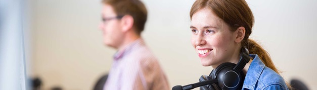 smiling student wearing a headset in class