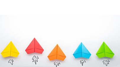 Different coloured paper planes laying next to one another.