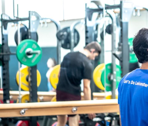 Students talking in the weights area of the gym